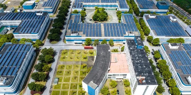 Solar Panels for Manufacturing Plants. An image of a large manufacturing plant with solar panel solutions installed on the roof. 