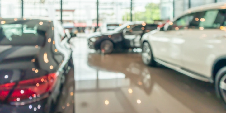 Solar panels for Car Dealerships. An image of new cars in showroom interior with a blurred abstract background.